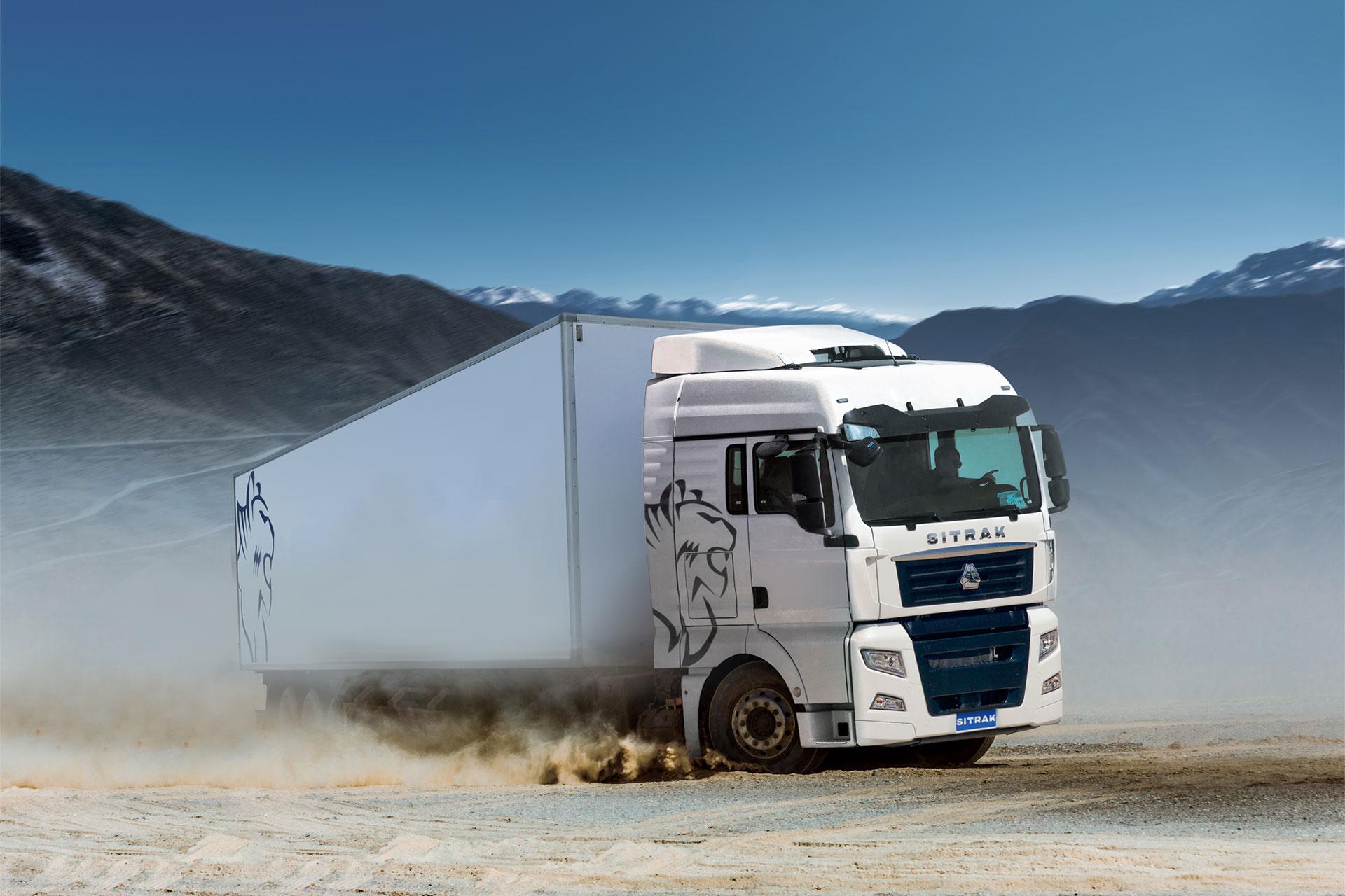 SITRAK tractor unit hauling a box trailer on a dusty mountain road